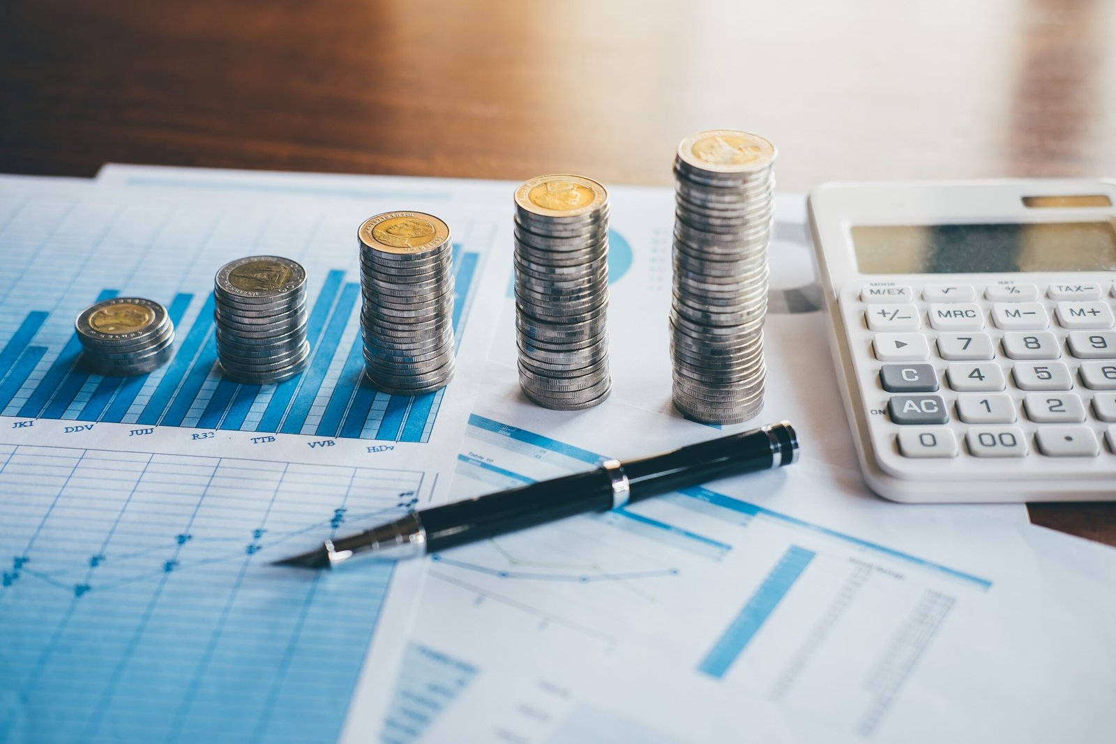 Business finance with report document, stacking coins for step up growing business to profit and saving with wealth management.